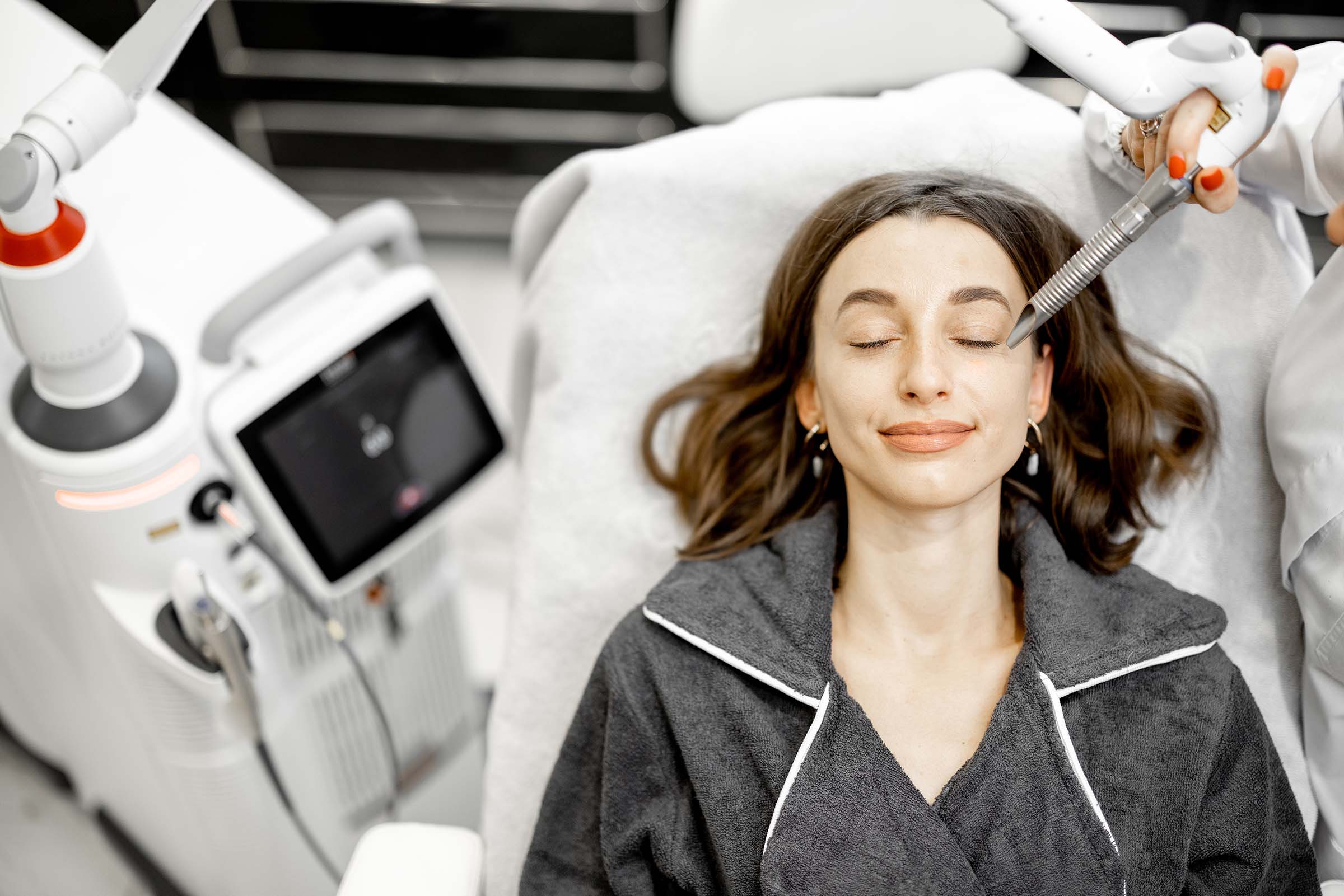 cosmetologist doing laser facelifting procedure in B9FYGUC